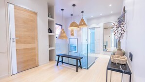 A modern hallway with a wooden door, a bench, and a glass partition. - Wonderful Villa, swimming pool and parking (Nice)