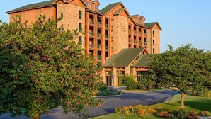 A multi-story hotel with a stone facade, multiple balconies, and a well-maintained lawn. -  Branson Woods 2 Bedrooms/2 Bathrooms Grand Villa (Branson)