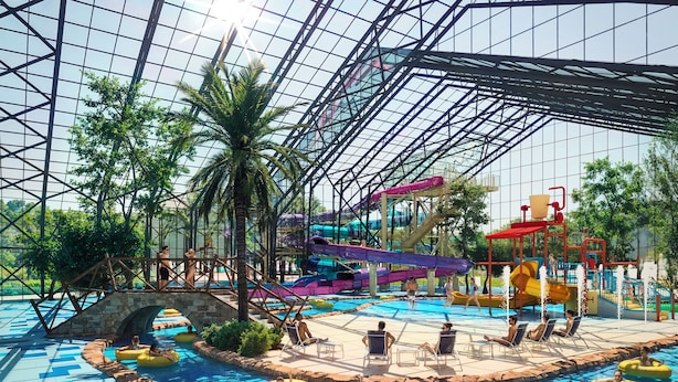 Een overdekt waterpark met een groot zwembad, glijbanen en opblaasbare tubes.