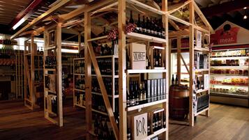 Una tienda de vinos con estantes de madera y una sección de carnes.