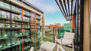 Un edificio moderno con numerosi balconi, ringhiere in vetro e zone relax all'aperto.