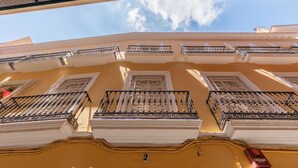 A building with multiple balconies, each with ornate railings and a geometric window design. - Cathedral PentHouse (Sevilla)