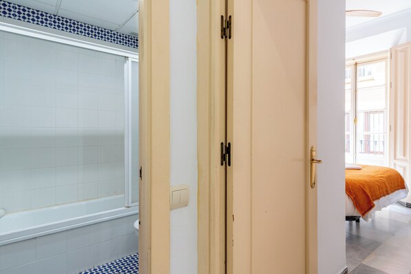 Ein Badezimmer mit Badewanne, Toilette und Duschbereich.