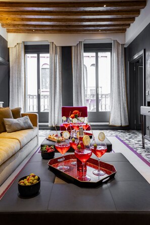 A modern living room with a sofa, a tray table with drinks, and a view of the outdoors. - La Dimora di Lady J A San Marco Townhouse (Venecia)