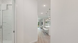 A modern bathroom with a glass shower enclosure and a white marble backsplash.