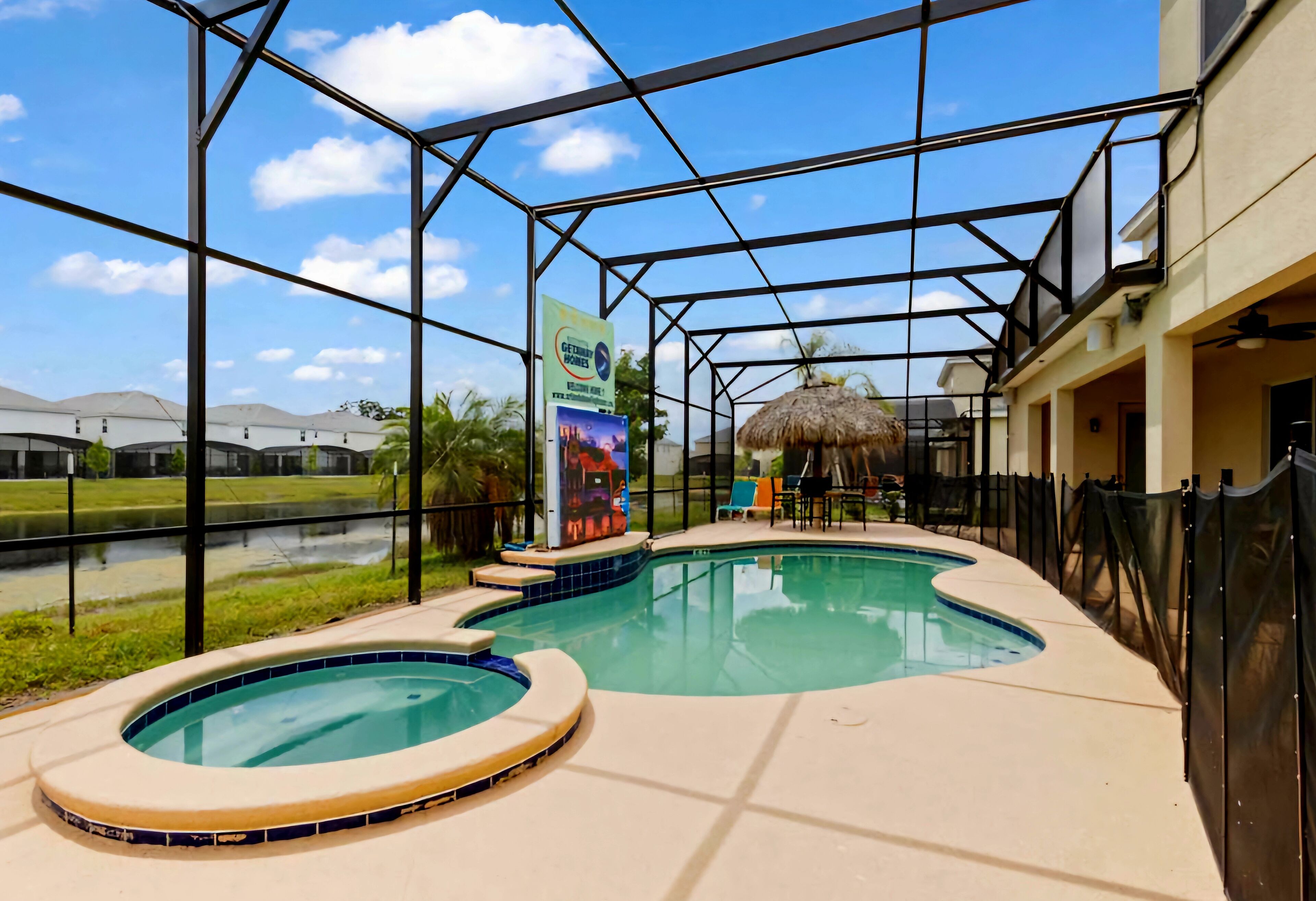 A pool area with a hot tub, a covered seating area, and a view of the surrounding landscape.