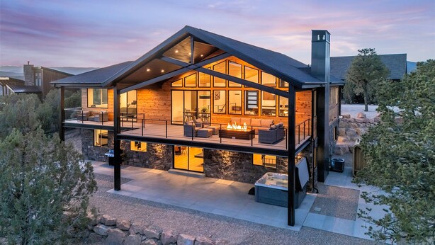 A modern house with a large deck, stone walls, and a fireplace. - High Desert Home | Modern Luxury Near Zion NP (Orderville)