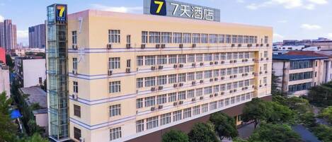Un hotel de varios pisos con un llamativo letrero con el número '7' en la fachada, que indica que es el séptimo hotel de una serie.