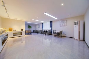 Un vestíbulo de hotel espacioso con mostrador de recepción, zona de estar y un amplio ventanal.