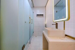 A modern bathroom with a large mirror, a sink, and cabinets. - 7Days Inn Hotel (Zhoukou Wuyi Square City Central Hospital) (Zhoukou)