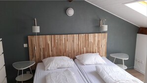 A room with two beds, a wooden headboard, two bedside tables, and a skylight. - Quiet 3*** listed vacation home with swimming pool (Saint-Julien-en-Born)