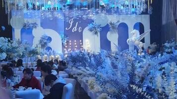 A formal event with a stage, floral decorations, and seated guests.
