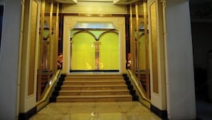 A grand entrance with a staircase leading to a yellow-lit room. - Xinxiang Jinghua Tropical Mineral Spring Health Garden (Xinxiang County)
