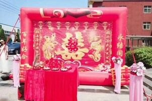 Una estructura en forma de globo rojo con caracteres chinos y una mesa con ofrendas.
