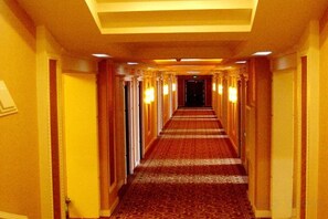 A hotel hallway with carpeted floors, doors on both sides, and overhead lighting. - Xinxiang Jinghua Tropical Mineral Spring Health Garden (Xinxiang County)