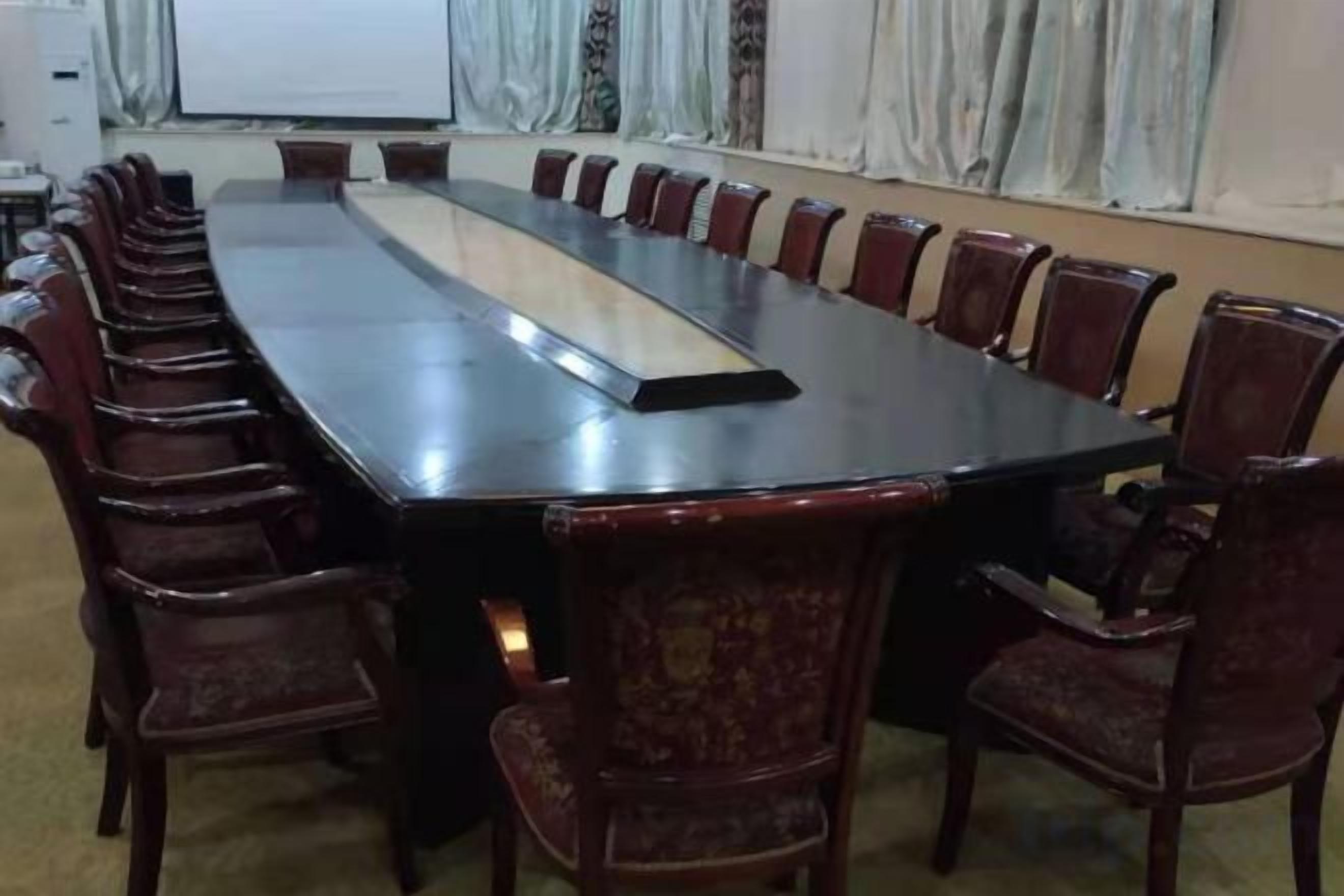 A conference room with a long table and chairs.