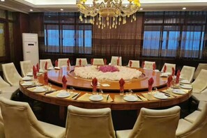 A conference room with a round table, chairs, and a chandelier. - Xinxiang Jinghua Tropical Mineral Spring Health Garden (Xinxiang County)