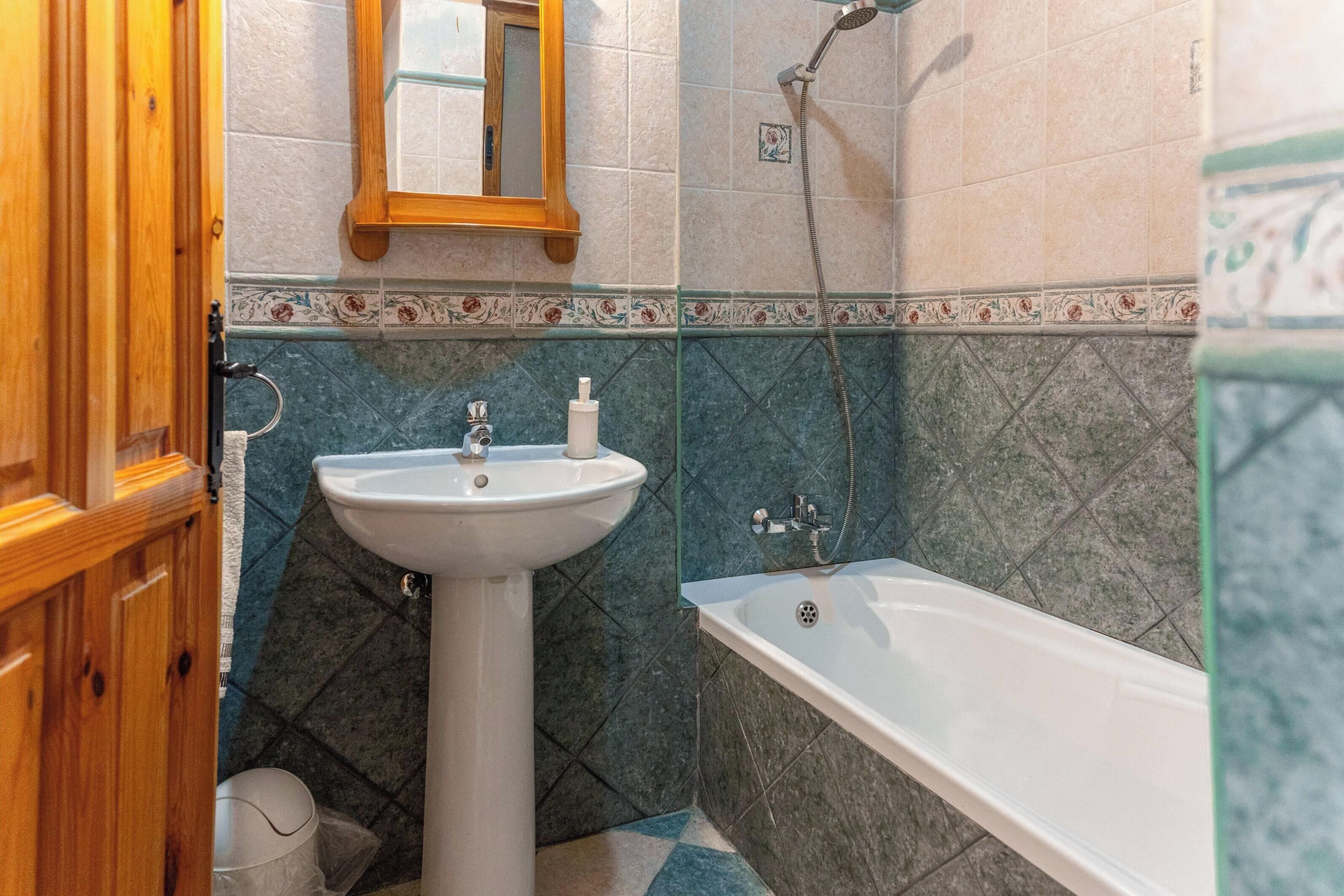 A bathroom with a white sink, a bathtub, and a shower.