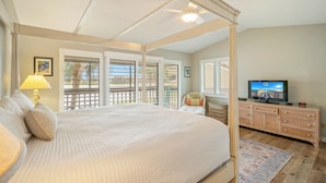 A bedroom with a four-poster bed, a television, a dresser, and a balcony with a view. - Seascape Boardwalk Villa 199*5 minute walk to beach! (Miramar Beach)