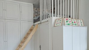 A room with a wooden staircase, white wardrobes, a small bench, and framed pictures on the wall. - Spacious, bright and central self-contained studio in a chambre d'hôte (Marseille)