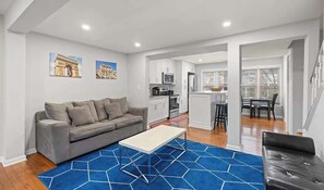 Relax in this stylish living space with a sofa, coffee table, and kitchen area.