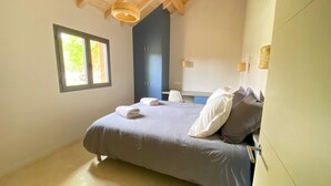 A bedroom with a bed, pillows, a window, and a door. - Villa Le Charles with swimming pool ideal for large families and groups (Lit-et-Mixe)
