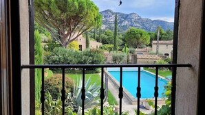 A view from a balcony with a pool, surrounded by greenery and mountains in the background. - La Villa de Robion Su (Robion)