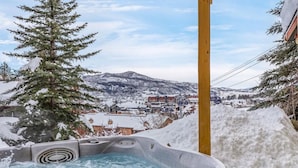 A hot tub with a snowy mountain view, surrounded by snow. - Victorian Under the Gondola: Main House (Steamboat Springs)