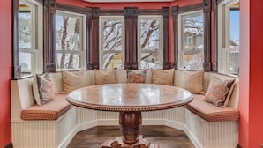 A corner seating area with a round table and built-in benches. - Victorian Under the Gondola: Main House (Steamboat Springs)