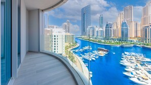 Un balcón con vistas a un puerto deportivo y edificios altos.