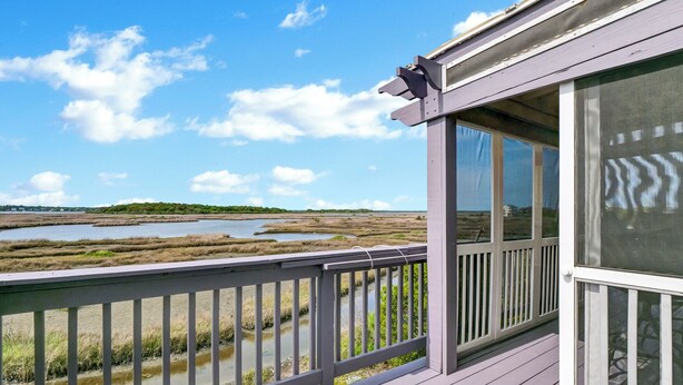 A wooden deck with a view of a marshy landscape and a body of water. - Waterfront Stay w/ Stunning Views, Beach Access, Outdoor Shower & Lift (North Topsail Beach)