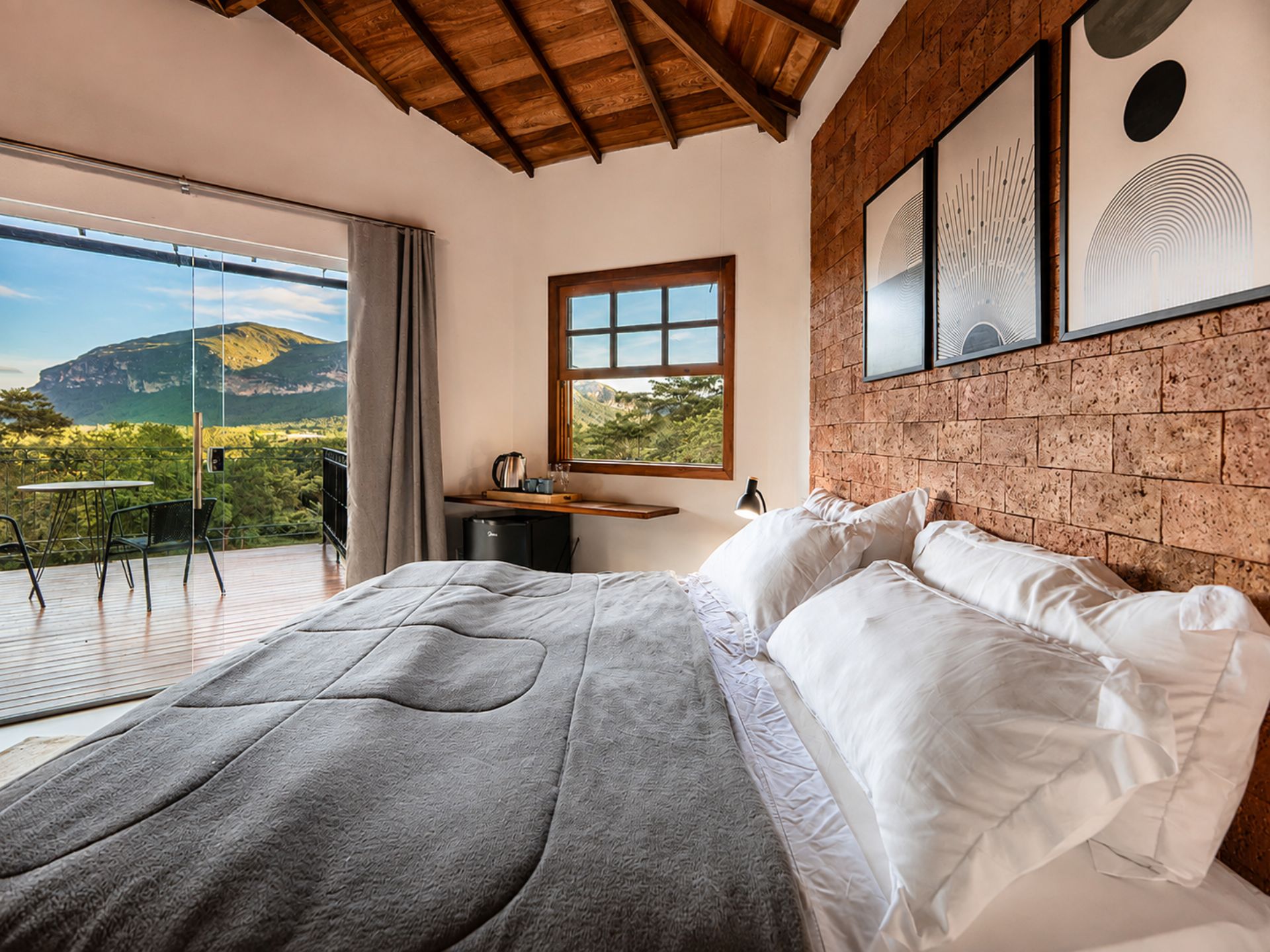 Un dormitorio con cama, escritorio y ventana con vistas panorámicas.