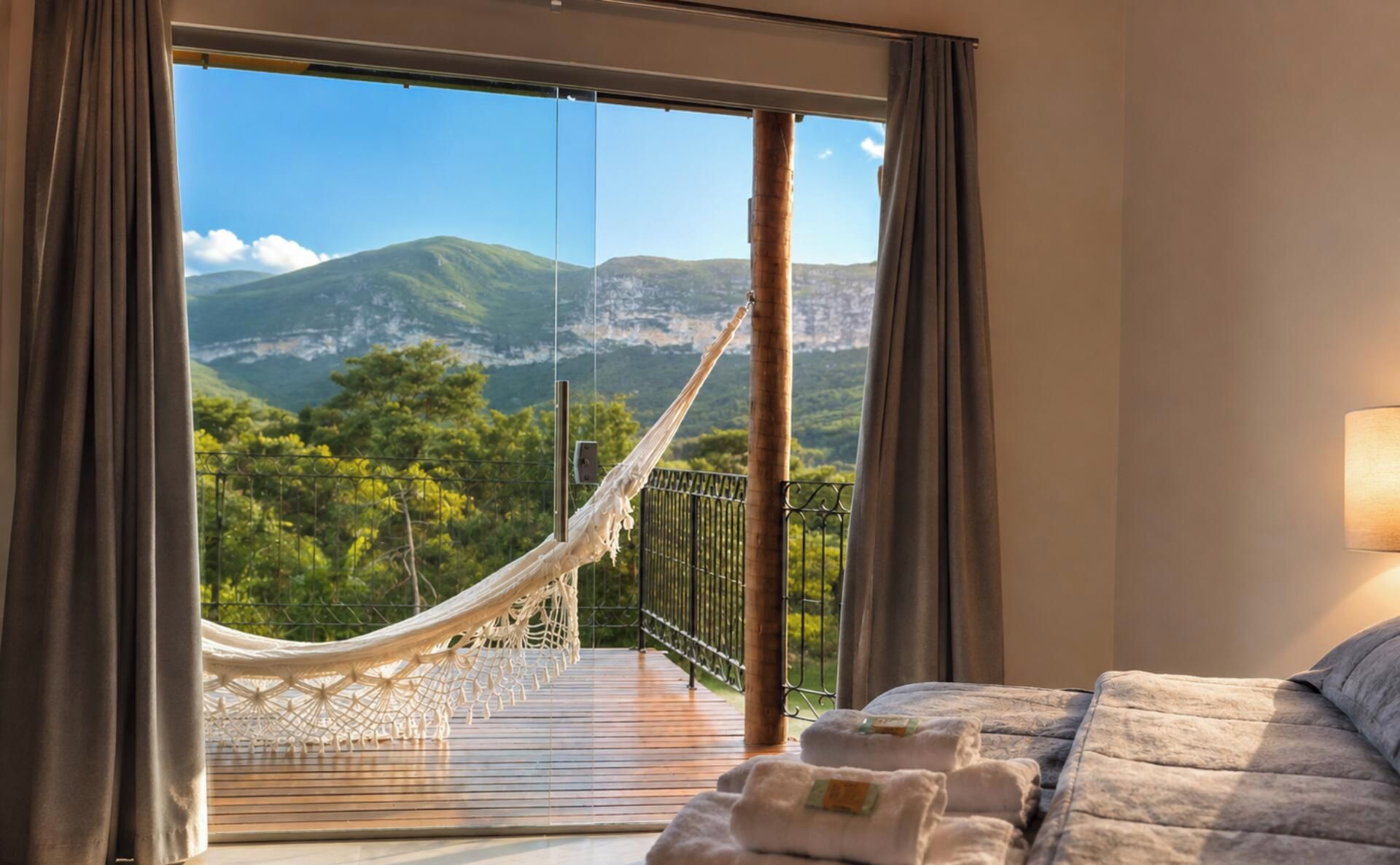 Una habitación con cama, hamaca y vistas a un paisaje montañoso.