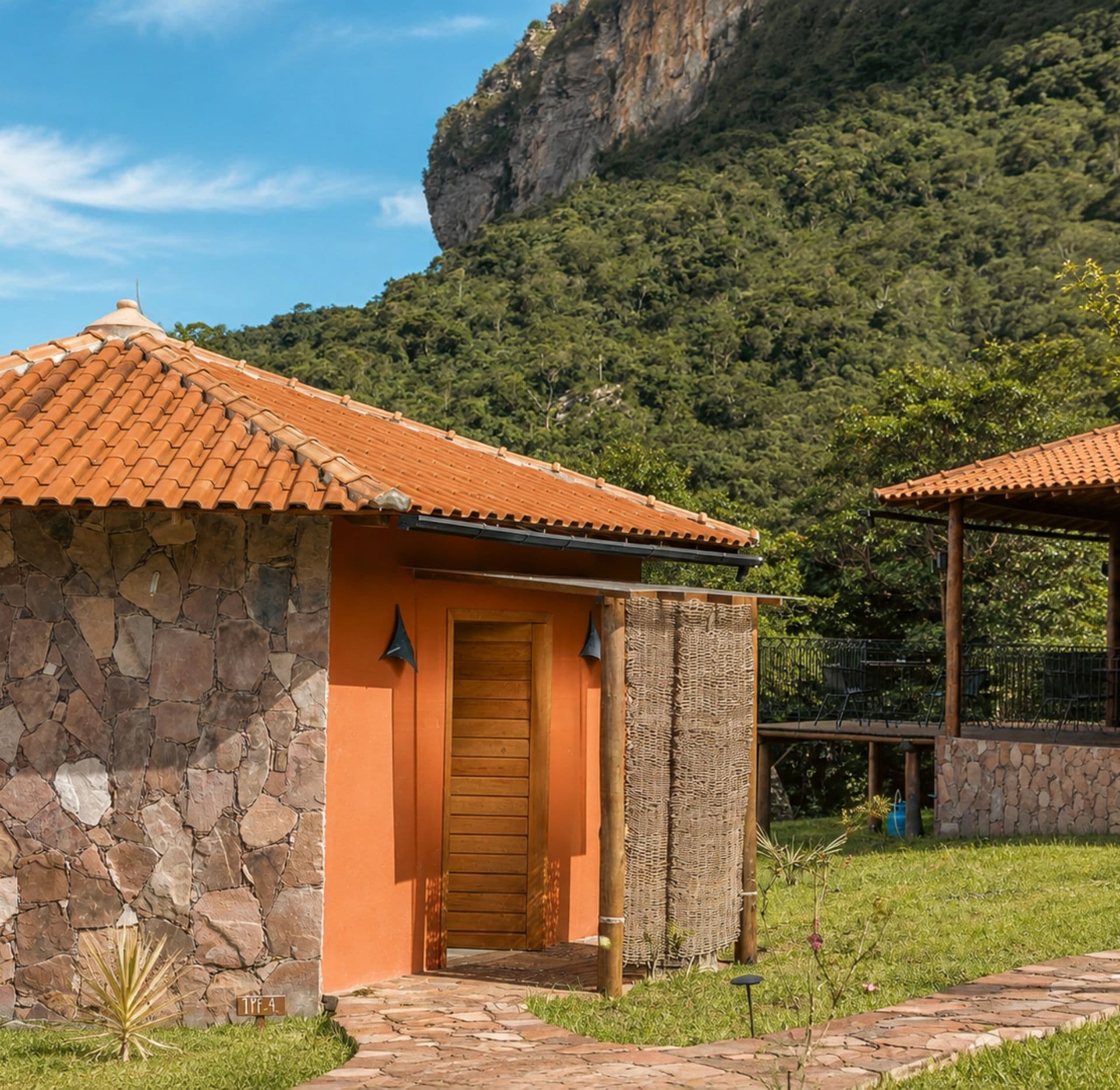 A stone building with a tiled roof, a wooden door, and a stone wall.