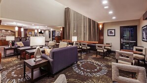 A hotel lobby with a seating area, a reception desk, and a large vertical panel. - Free Breakfast. Outdoor Pool. King Suite Close to the Convention Center (Fort Worth)