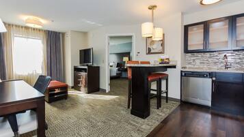 Une chambre d’hôtel compacte comprenant un coin repas, une kitchenette et un téléviseur.