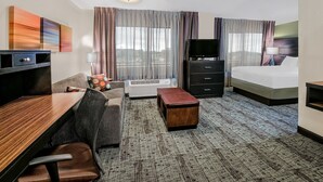 A hotel room with a bed, a desk with a chair, a TV, a dresser, and a large window with curtains. - Free Breakfast. Shared Pool & Hot Tub. Studio Near Texas Tech University & University Medical Center. (Lubbock)