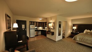 A hotel room with a bed, a desk, a chair, a small kitchenette, and a bathroom. - Relaxing Retreat! Studio Suite in Liverpool | Fitness Center + Free Breakfast (Liverpool)