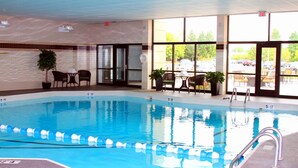 An indoor swimming pool with clear lane dividers, a lifeguard chair, and a seating area with chairs and tables. - Relaxing Retreat! Studio Suite in Liverpool | Fitness Center + Free Breakfast (Liverpool)