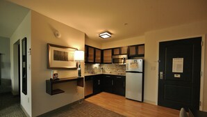 A modern kitchen with dark cabinets, a stainless steel refrigerator, and a microwave. - Relaxing Retreat! Studio Suite in Liverpool | Fitness Center + Free Breakfast (Liverpool)
