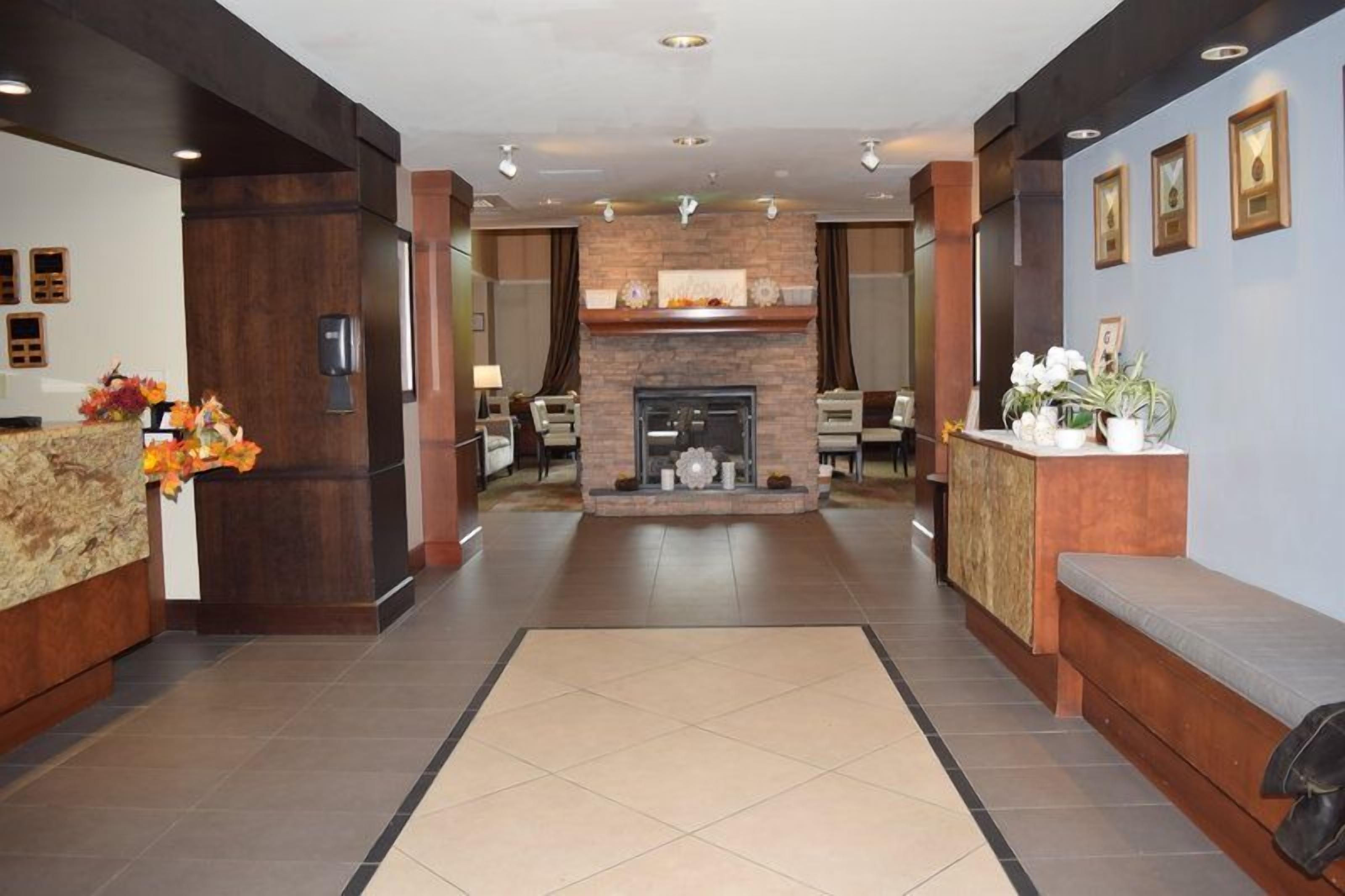 Un vestíbulo de hotel con mostrador de recepción, zona de estar y chimenea.