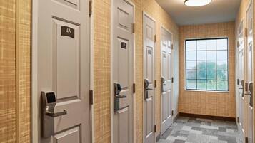 A hallway with multiple doors, each marked with a number, leading to rooms.