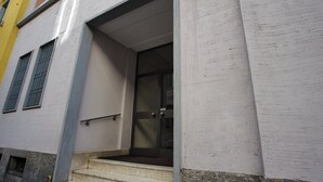A building entrance with a glass door, a metal handrail, and a set of stairs leading up to it. - Adorable flat near centre (Milan)