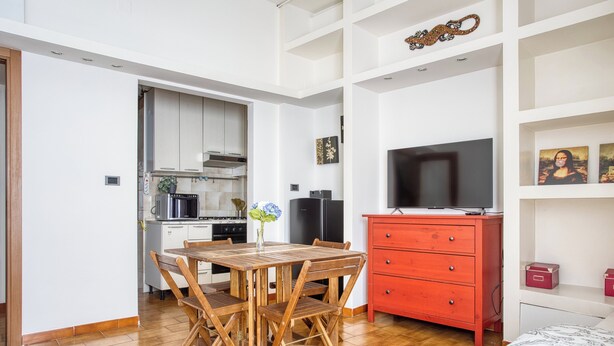 A compact living space with a dining area, kitchenette, and a television. - Adorable flat near centre (Milan)