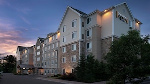 A multi-story hotel with a stone facade, multiple windows, and a sign indicating it is a Staybridge Suites hotel.