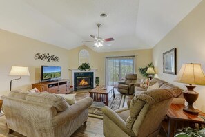 A living room with a fireplace, television, and seating area. - Whispering Pine 653| Two Bedroom| Two Bathroom | Sleeps 6 | Jacuzzi Tub (Pigeon Forge)