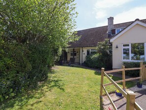 A house with a tiled roof, a garden with a wooden fence, and a small shed. - Rosemarie Annexe (Axminster)