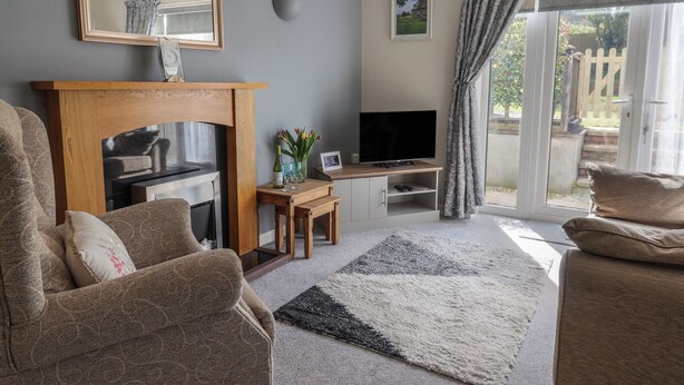 Ein Wohnzimmer mit Kamin, Fernseher und Sitzecke.