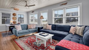 A living room with a blue sofa, a white coffee table, and a red patterned rug. - Ocean View-Pet Friendly- 1min walk to beach-sleeps 6 (Surf City)