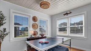 A room with a ping pong table, white walls, and large windows with blinds. - Ocean View-Pet Friendly- 1min walk to beach-sleeps 6 (Surf City)
